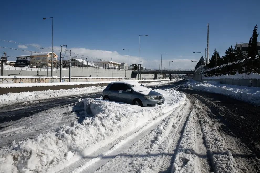 Athens (Greece), 25/01/2022.- Firefighiting personnel try to take a car off the snow at Attiki odos, the Greek capital's biggest ring road, following a heavy snowfall in Athens, Greece, 25 January 2022. Thousands of motorists are trapped on the highway of Attiki odos in their cars and trucks during the blizzard. A bad weather front, named Elpis by the National Meteorological Services (EMY), has caused frozen temperatures, stormy winds and heavy snowfall since 22 January. (Incendio, Grecia, Estados Unidos, Atenas) EFE/EPA/YIANNIS KOLESIDIS
 GREECE WEATHER AFTERMATH