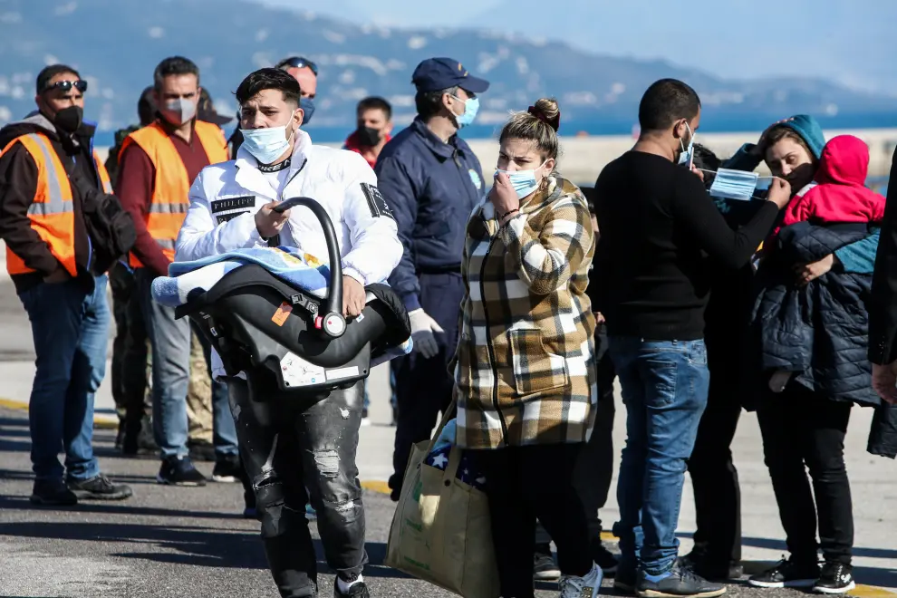 Passengers from the Italian-flagged Euroferry Olympia stand on a Greek coast guard vessel at the port of Corfu after being rescued from the ship that caught fire off the island of Corfu, Greece, February 18, 2022. Stamatis Katapodis/Eurokinissi via REUTERS ATTENTION EDITORS - THIS IMAGE WAS PROVIDED BY A THIRD PARTY. NO RESALES. NO ARCHIVE. GREECE OUT. NO COMMERCIAL OR EDITORIAL SALES IN GREECE. GREECE-FERRY/FIRE