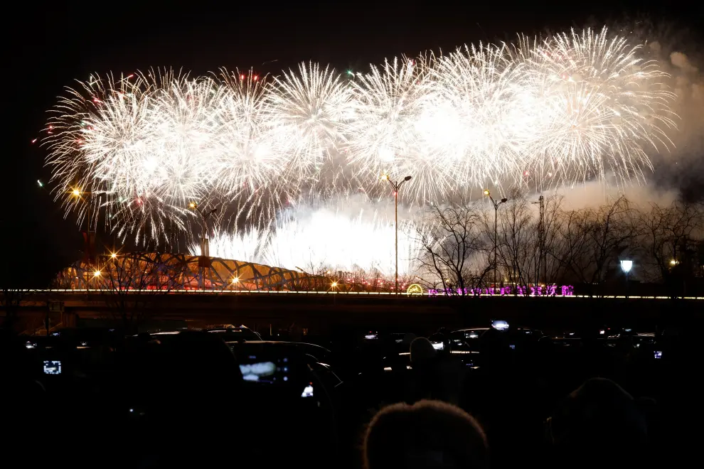 People watch as fireworks explode over the National Stadium, also known as the Bird's Nest, at the end of the closing ceremony of the Beijing 2022 Winter Olympics, in Beijing, China February 20, 2022. REUTERS/Carlos Garcia Rawlins OLYMPICS-2022-CLOSING/