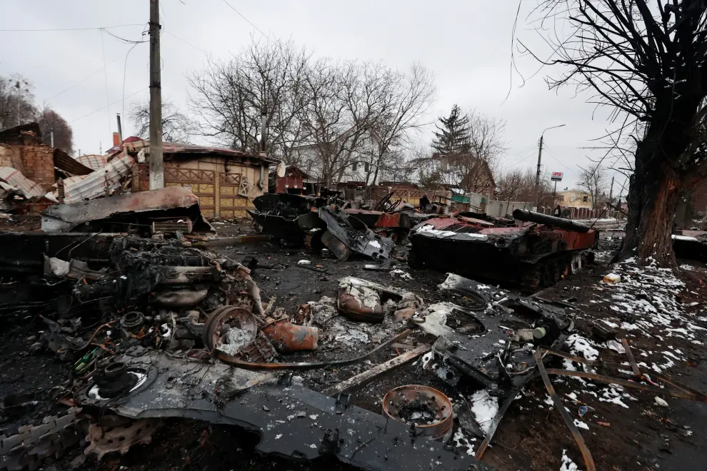 A local resident stands next to a destroyed military vehicle, as Russia's invasion of Ukraine continues, in the town of Bucha in the Kyiv region, Ukraine March 1, 2022. Picture taken March 1, 2022. REUTERS/Serhii Nuzhnenko UKRAINE-CRISIS/BUCHA-AFTERMATH
