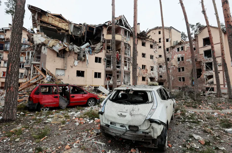 People carry belongings out of a residential building destroyed by recent shelling, as Russia's invasion of Ukraine continues, in the city of Irpin in the Kyiv region, Ukraine March 2, 2022. REUTERS/Serhii Nuzhnenko UKRAINE-CRISIS/IRPIN