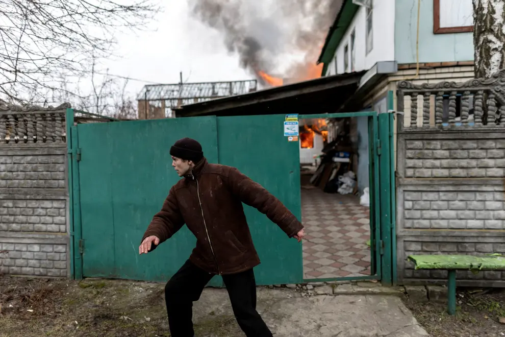A local resident reacts as a house is on fire after heavy shelling on the only escape route used by locals to leave the town of Irpin, while Russian troops advance towards the capital, 24km from Kyiv, Ukraine March 6, 2022. REUTERS/Carlos Barria UKRAINE-CRISIS/IRPIN