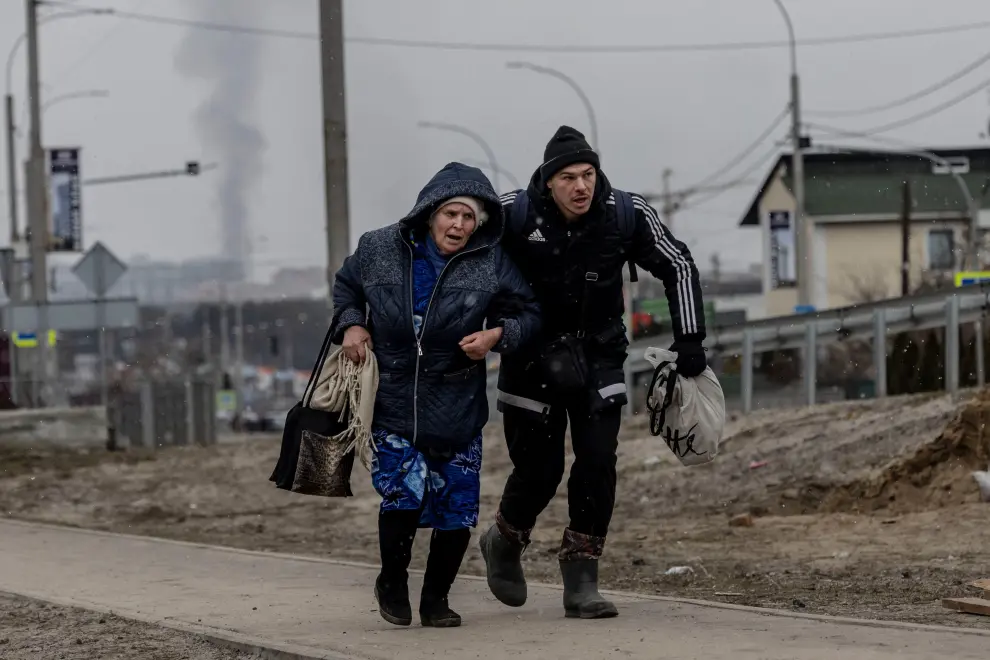 Journalists run for cover after heavy shelling on the only escape route used by locals, while Russian troops advance towards the capital, in Irpin, near Kyiv, Ukraine March 6, 2022. REUTERS/Carlos Barria UKRAINE-CRISIS/IRPIN