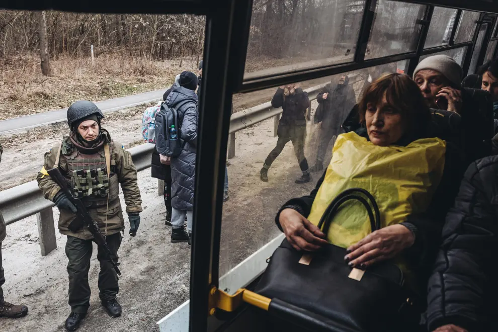 Residents wait for a bus as they escape from the town of Irpin, after heavy shelling on the only escape route used by locals, while Russian troops advance towards the capital, in Irpin, near Kyiv, Ukraine, March 6, 2022. REUTERS/Carlos Barria UKRAINE-CRISIS/IRPIN