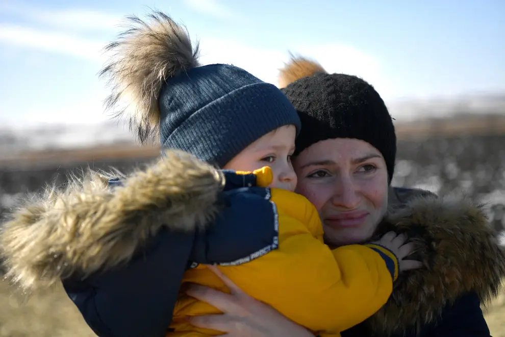 Olga abraza a su hijo David después de bajar del automóvil con el que pudieron cruzar la frontera huyendo de Kharkiv (Ucrania), en una imagen tomada en el cruce fronterizo de Siret (Rumanía).