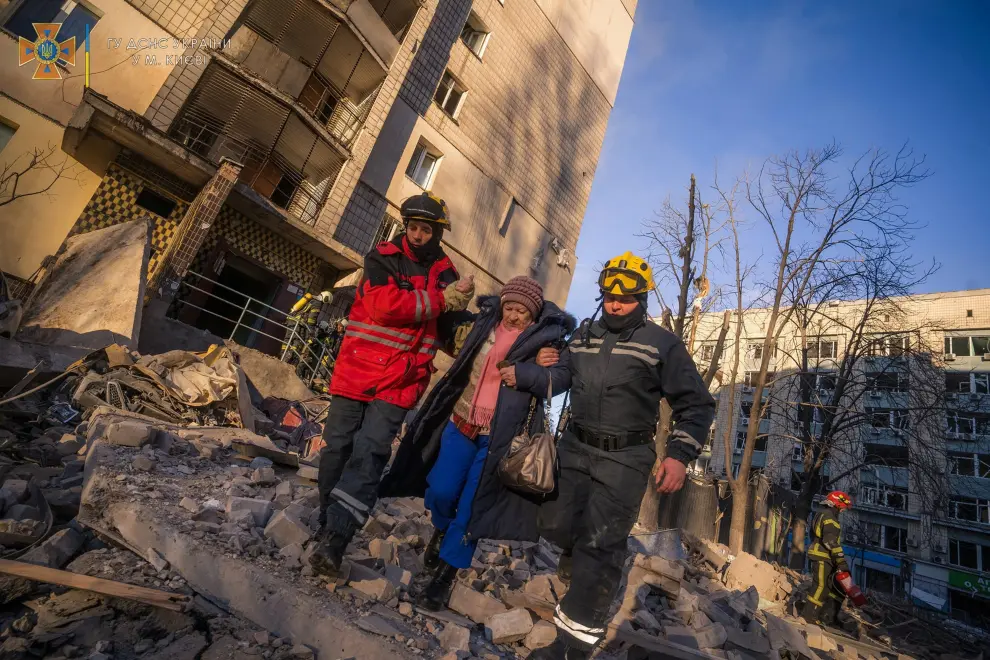 A psychologist helps people evacuated from a residential building damaged by shelling, as Russia's attack on Ukraine continues, in Kyiv, Ukraine, in this handout picture released March 16, 2022.  Press service of the State Emergency Service of Ukraine/Handout via REUTERS ATTENTION EDITORS - THIS IMAGE HAS BEEN SUPPLIED BY A THIRD PARTY. UKRAINE-CRISIS/KYIV