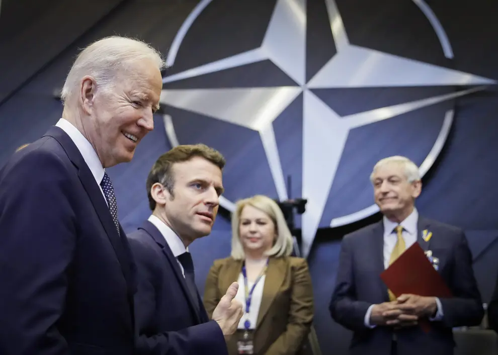 U.S. President Joe Biden talks to France's President Emmanuel Macron during a NATO summit to discuss Russia's invasion of Ukraine, at the alliance's headquarters in Brussels, Belgium, March 24, 2022. REUTERS/Gonzalo Fuentes UKRAINE-CRISIS/NATO
