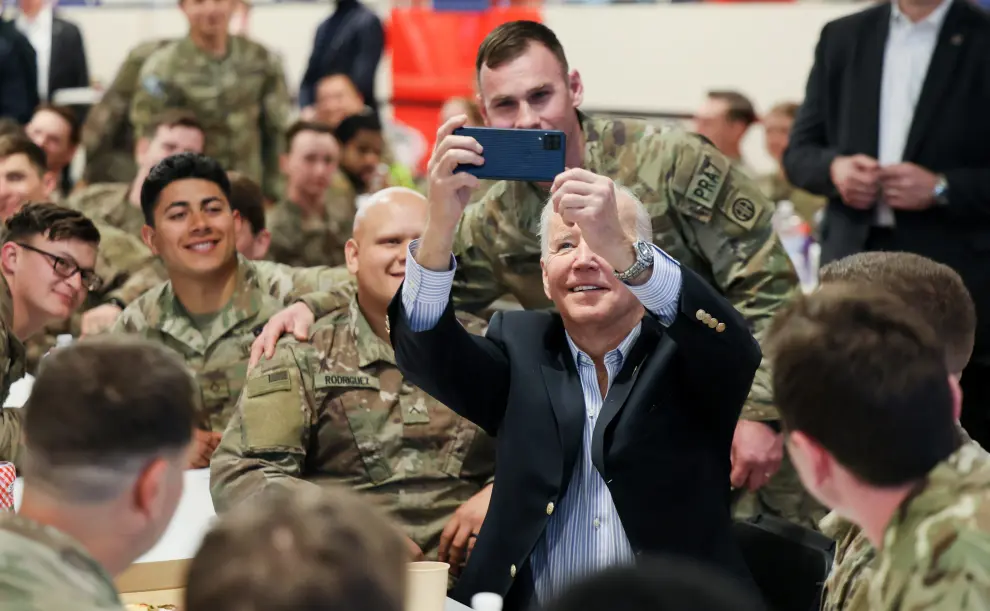 U.S. President Joe Biden eats pizza as he meets with U.S. Army soldiers assigned to the 82nd Airborne Division at the G2 Arena in Jasionka, near Rzeszow, Poland, March 25, 2022. REUTERS/Evelyn Hockstein UKRAINE-CRISIS/USA-POLAND
