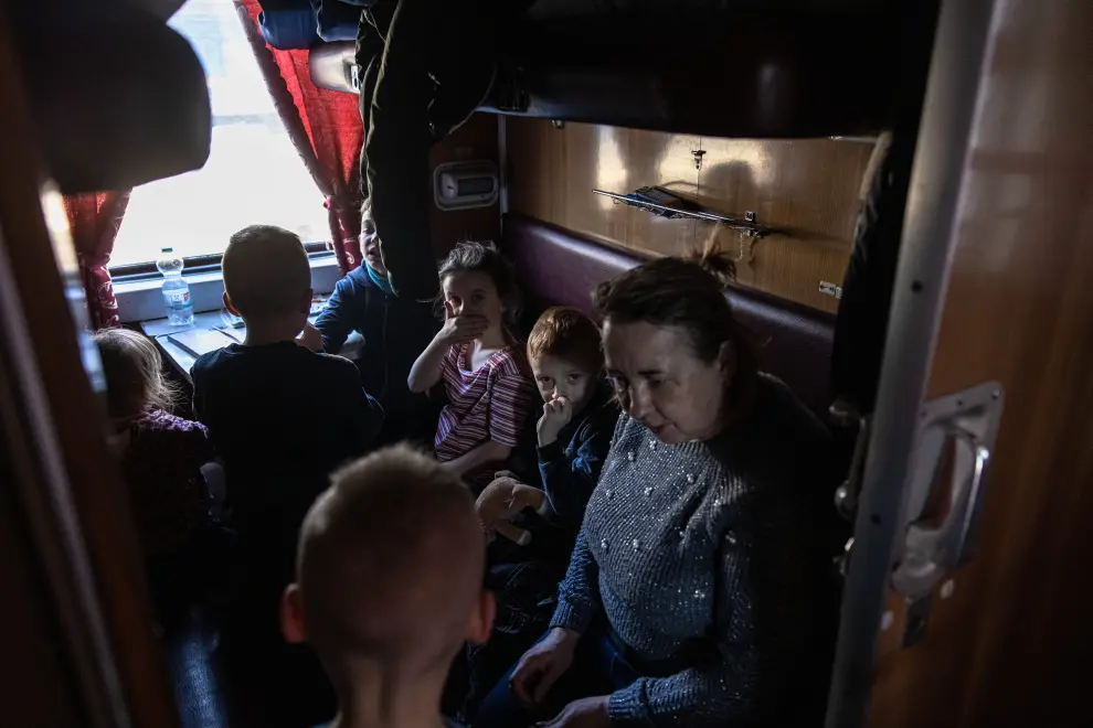 Zaporizhzhia (Ukraine), 26/03/2022.- Orphan children who fled from the occupied by the Russian army Ukrainian town of Polohy, board with their teachers an evacuation train to the western part of Ukraine, at the railway station in Zaporizhzhia, southeastern Ukraine, 26 March 2022. Around 30 orphan children from an orphanage in the Polohy town, Zaporizhzhia region, following the fightings and occupation of the town by the Russian military, fled with their teachers to the city of Zaporizhzhia. From there they went to the western part of Ukraine, where they hope to find a safe place far from the active war zones. (Rusia, Ucrania) EFE/EPA/ROMAN PILIPEY ATTENTION: This Image is part of a PHOTO SET
 PHOTO SET UKRAINE RUSSIA WAR EVACUATION OF ORPHAN CHILDREN