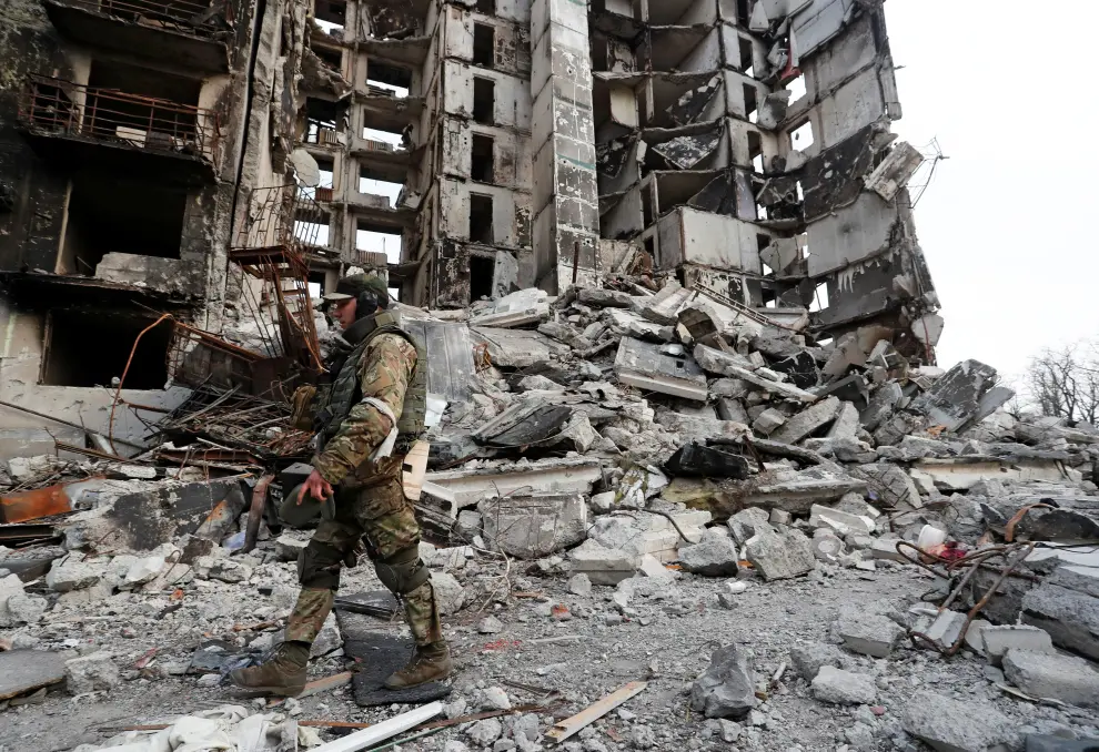 A service member of pro-Russian troops stands on the ruins of an apartment building destroyed during Ukraine-Russia conflict in the besieged southern port city of Mariupol, Ukraine March 30, 2022. REUTERS/Alexander Ermochenko UKRAINE-CRISIS/MARIUPOL