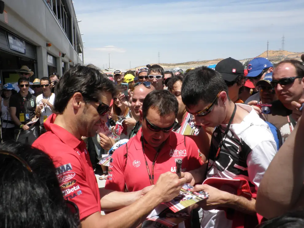 Carlos Checa firma autógrafos a unos aficionados en Motorland en 2011.