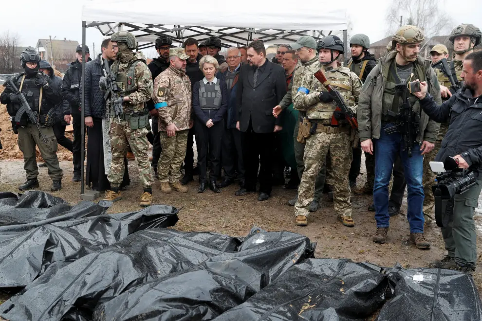 Ukrainian servicemen stand guard next to bodies that were exhumed from a mass grave, during a visit of European Commission President Ursula von der Leyen, High Representative of the European Union for Foreign Affairs and Security Policy Josep Borrell, and Ukraine's Prime Minister Denys Shmyhal in the town of Bucha, as Russia's attack on Ukraine continues, outside of Kyiv, Ukraine April 8, 2022. REUTERS/Janis Laizans UKRAINE-CRISIS/EU-BUCHA