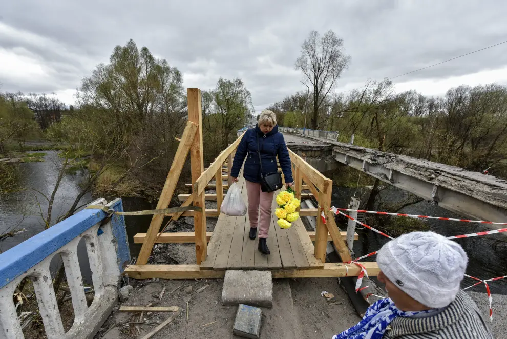 Malyn (Ukraine), 16/04/2022.- People cross a makeshift wooden bridge built on the wreckage of the old one destroyed amid fighting between Russian and Ukrainian troops, in Malyn, Zhytomyr region, Ukraine, 16 April 2022. On 24 February Russian troops entered Ukrainian territory resulting in fighting and destruction in the country, a huge flow of refugees, and multiple sanctions against Russia. (Rusia, Ucrania) EFE/EPA/OLEG PETRASYUK
 UKRAINE RUSSIA CONFLICT