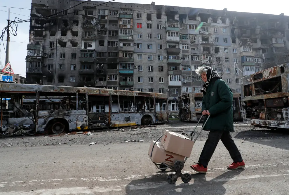Local residents walk past buildings destroyed during Ukraine-Russia conflict in the southern port city of Mariupol, Ukraine April 19, 2022. REUTERS/Alexander Ermochenko UKRAINE-CRISIS/MARIUPOL