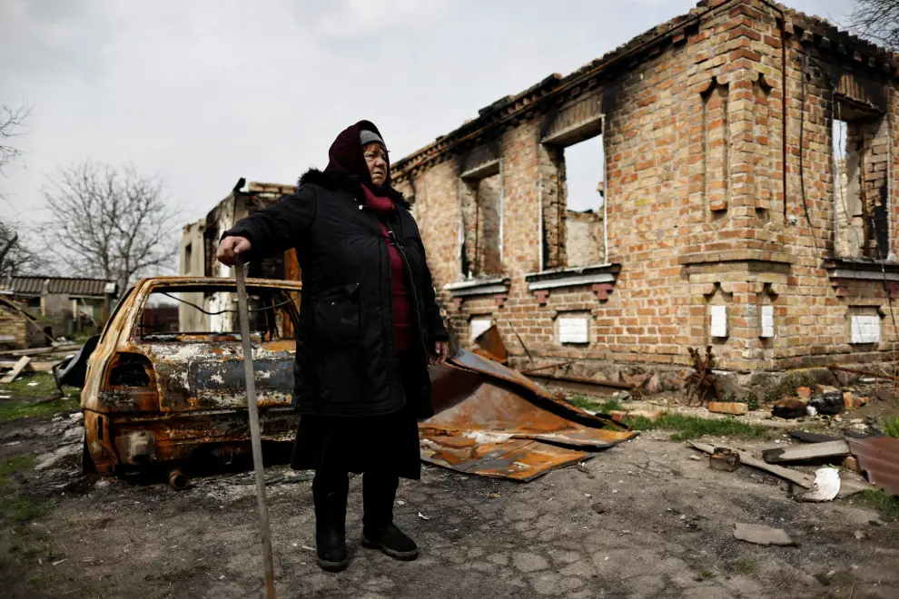 Ludmila Sadlova, 72, sits outside her house, that according to her was hit by rockets on March 12, amid Russia's invasion of Ukraine, in Ozera, Kyiv region, Ukraine April 23, 2022. The writing on the gates read "People live here" and "Children" REUTERS/Zohra Bensemra UKRAINE-CRISIS/