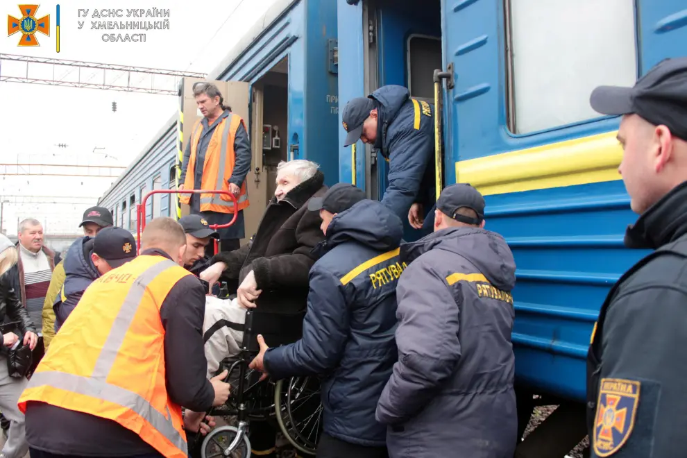 A Ukrainian Emergency Service member helps an elderly woman in a wheelchair, after she arrived at Khmelnytskyi train station amid evacuation efforts, as Russia's invasion of Ukraine continues, in Khmelnytskyi, Ukraine in this handout picture obtained by Reuters on April 23, 2022. State Emergency Service of Ukraine/Handout via REUTERS   THIS IMAGE HAS BEEN SUPPLIED BY A THIRD PARTY. MANDATORY CREDIT. UKRAINE-CRISIS/EVACUEES-ELDERLY