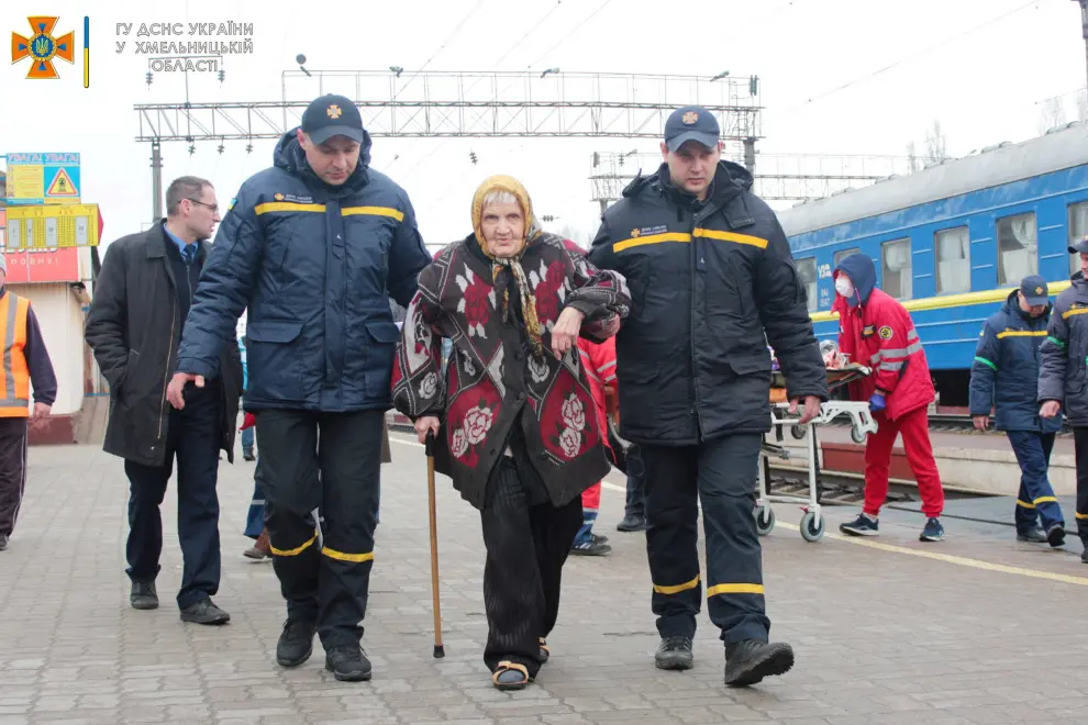 A Ukrainian Emergency Service member helps an elderly man in a wheelchair, after he arrived at Khmelnytskyi train station amid evacuation efforts, as Russia's invasion of Ukraine continues, in Khmelnytskyi, Ukraine in this handout picture obtained by Reuters on April 23, 2022. State Emergency Service of Ukraine/Handout via REUTERS   THIS IMAGE HAS BEEN SUPPLIED BY A THIRD PARTY. MANDATORY CREDIT. UKRAINE-CRISIS/EVACUEES-ELDERLY