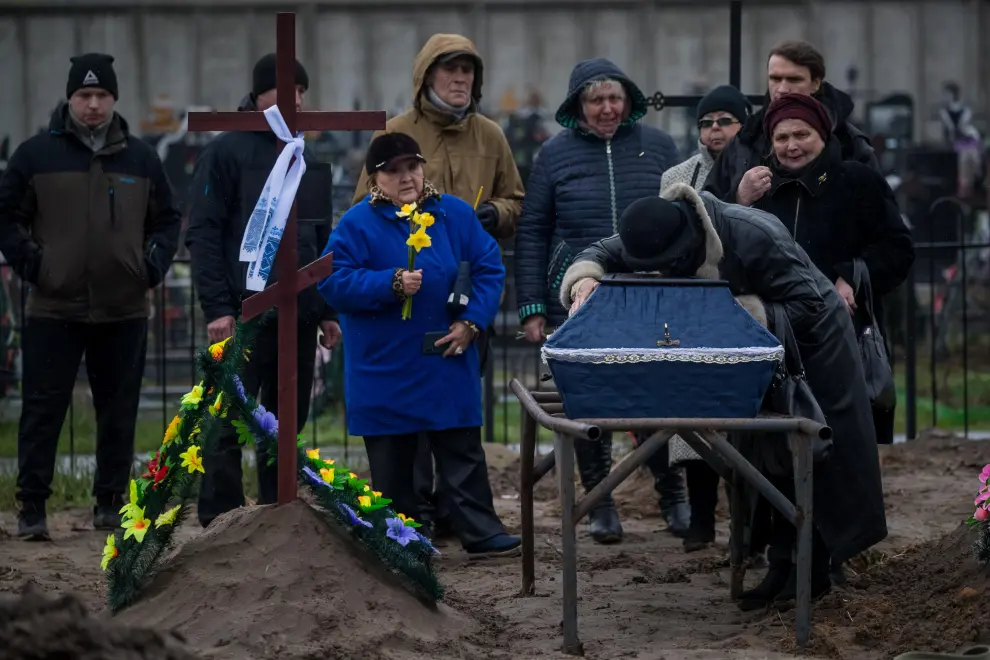 Varios familiares entierran a una persona en el cementerio de Bucha, en Ucrania, este viernes.