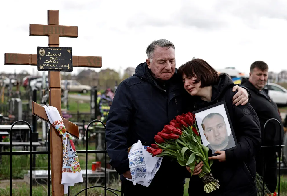 FILE PHOTO: People mourn at the cemetery in Bucha