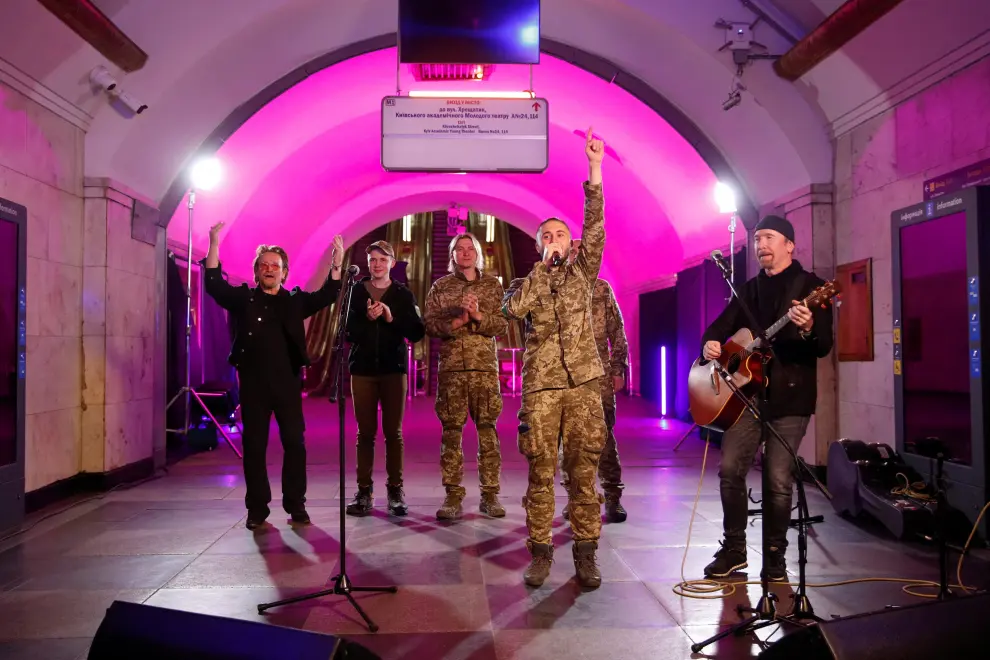 Bono, The Edge and Ukrainian serviceman, frontman of the Antytila band Taras Topolia sing during a performance for Ukrainian people inside a subway station, as Russia's attack on Ukraine continues, in Kyiv, Ukraine May 8, 2022.  REUTERS/Valentyn Ogirenko UKRAINE-CRISIS/BONO