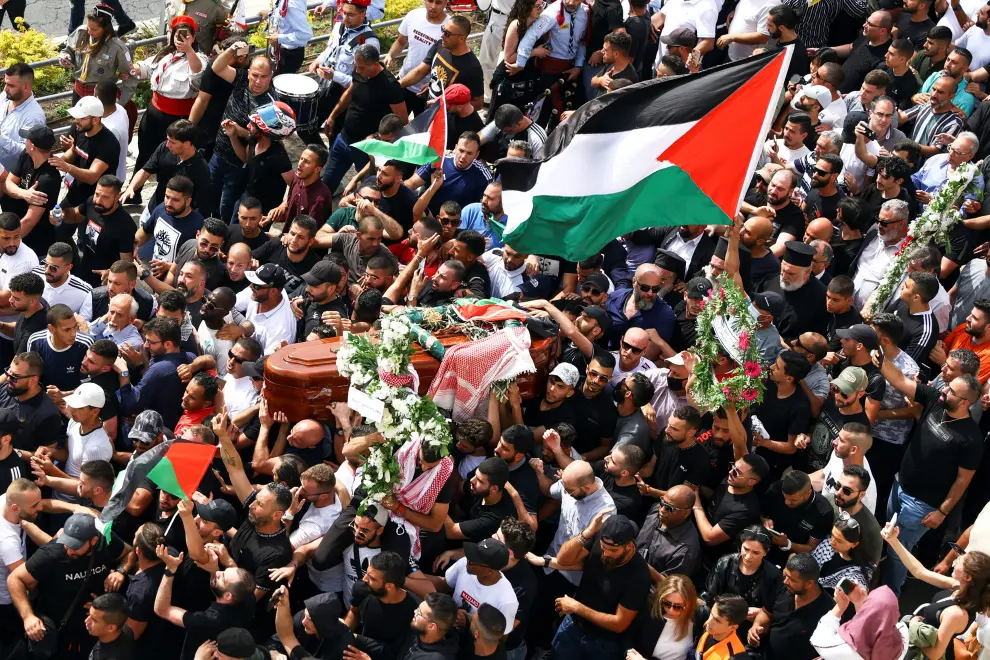 Family and friends carry the coffin of Al Jazeera reporter Shireen Abu Akleh, who was killed during an Israeli raid in Jenin in the occupied West Bank, as clashes erupted with Israeli security forces, during her funeral in Jerusalem, May 13, 2022. REUTERS/Ammar Awad ISRAEL-PALESTINIANS/JOURNALIST