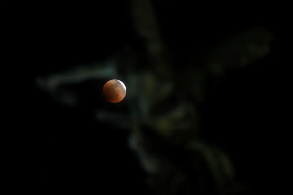 A full moon moves through the shadow of the earth during a "Blood Moon" lunar eclipse in San Salvador