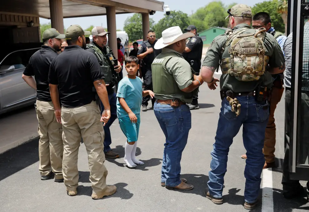 Children get on a school bus as law enforcement personnel guard the scene of a suspected shooting near Robb Elementary School in Uvalde, Texas, U.S. May 24, 2022.  REUTERS/Marco Bello TEXAS-SHOOTING/