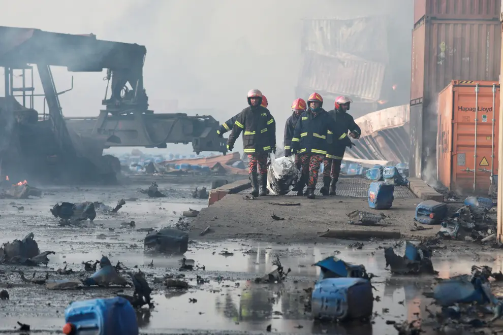 Firefighters carry a dead body from the spot after a massive fire broke out in an inland container depot at Sitakunda, near the port city Chittagong