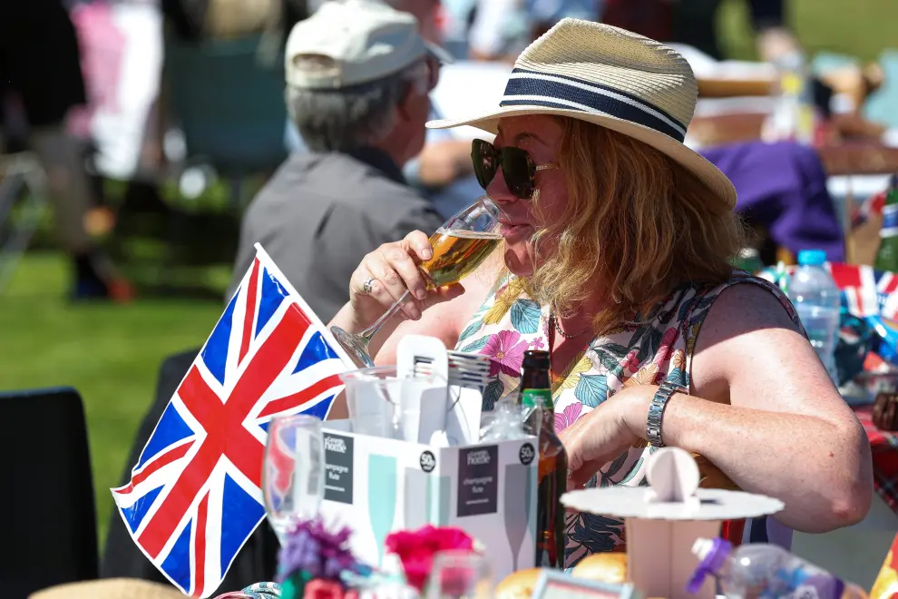 Women, of which one wearing a mask depicting Britain's Kate, Duchess of Cambridge, pose for a picture during a party celebrating the Queen's Platinum Jubilee at the Princess Royal and Duke of Fife Memorial Park in Braemar, Scotland June 5, 2022. REUTERS/Russell Cheyne BRITAIN-ROYALS/PLATINUM-JUBILEE BIG LUNCH