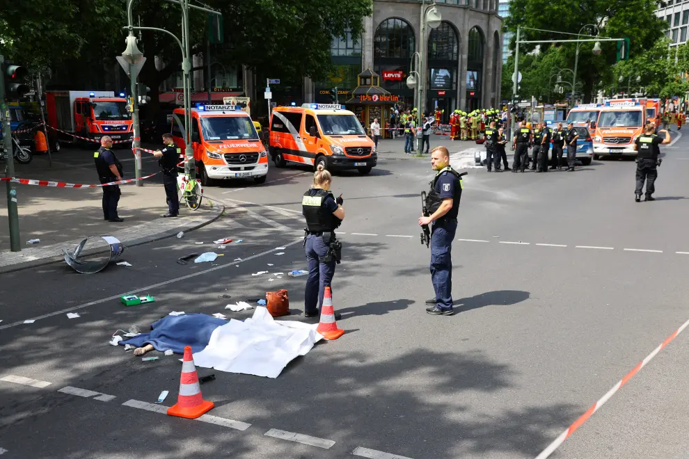 Berlin (Germany), 08/06/2022.- Police officers cover the body of a person after a car drove into a crowd of people in central Berlin, Germany, 08 June 2022. According to police, a man is said to have driven into a group of people in central Berlin. One person died and several others were injured in the accident. (Alemania) EFE/EPA/FILIP SINGER GERMANY BERLIN CAR PLOWS INTO CROWD