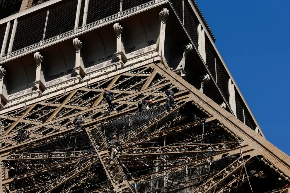 A worker climbs on the Eiffel tower during the 20th campaign of painting and stripping of the Eiffel tower in Paris, France, July 5, 2022. REUTERS/Benoit Tessier FRANCE-EIFFEL/RUST