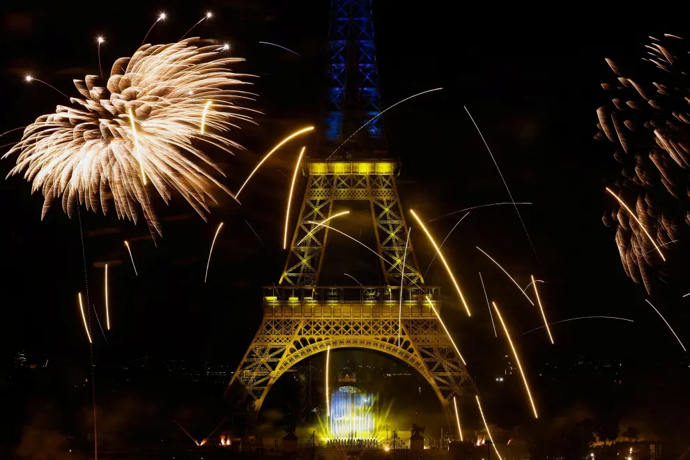 Fireworks explode around the Eiffel Tower, lighted with the colors of Ukraine, during celebrations to mark Bastille Day, in Paris, France, July 14, 2022. REUTERS/Benoit Tessier FRANCE-NATIONALDAY/FIREWORKS