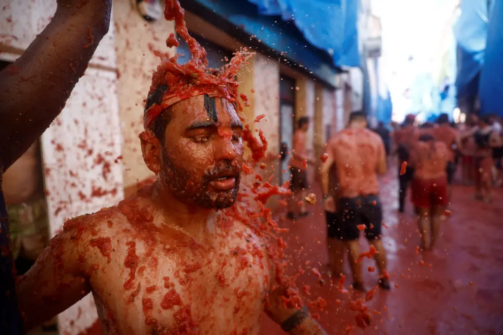 A reveler washes the tomato pulp with water during the annual "La Tomatina" food fight festival in Bunol, Spain August 31, 2022. REUTERS/Juan Medina SPAIN-CULTURE/TOMATO FIGHT