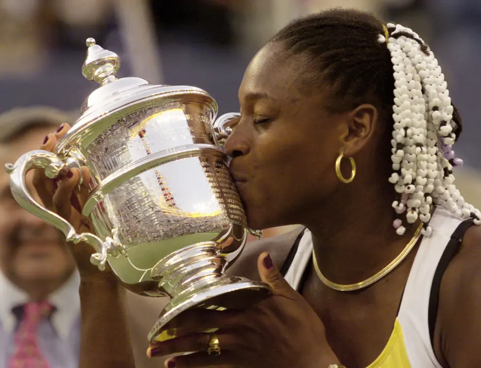 FILE PHOTO: Serena Williams of the U.S. embraces her trophy after defeating Victoria Azarenka of Belarus in their women's singles final match at the U.S. Open tennis championships in New York September 8, 2013.                    REUTERS/Mike Segar/File Photo (UNITED STATES  - Tags: SPORT TENNIS) TENNIS-USOPEN/SERENA