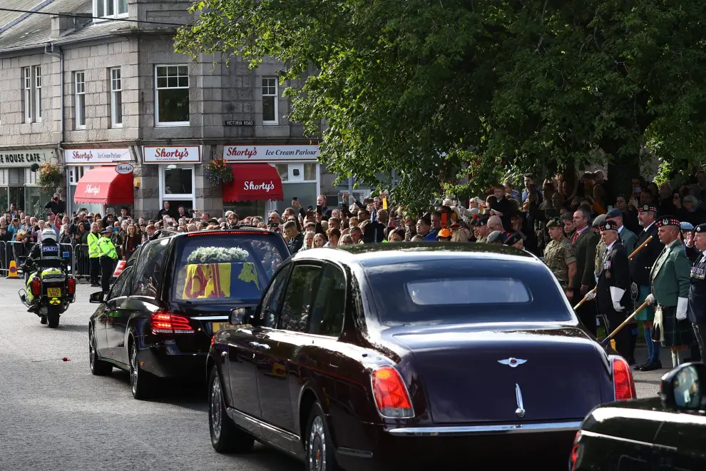 People line the street as the hearse carrying the coffin of Britain's Queen Elizabeth passes through the village of Ballater, near Balmoral, Scotland, Britain, September 11, 2022. REUTERS/Hannah McKay BRITAIN-ROYALS/QUEEN