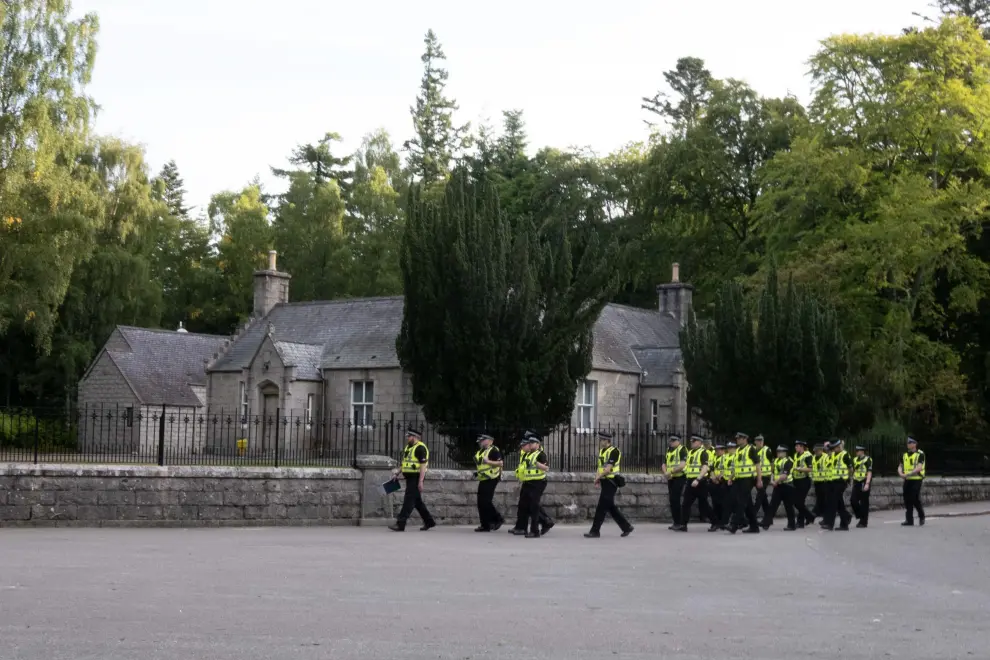 Balmoral (United Kingdom), 11/09/2022.- Police stand next to flowers left in tribute to Britain's late Queen Elizabeth II outside Balmoral Castle, Scotland, Britain, 11 September 2022. Britain's Queen Elizabeth II died at her Scottish estate on 08 September. The late queen will lie in state for 24 hours at St Giles' Cathedral in Edinburgh. (Reino Unido, Edimburgo) EFE/EPA/PAUL REID
 BRITAIN QUEEN ELIZABETH II