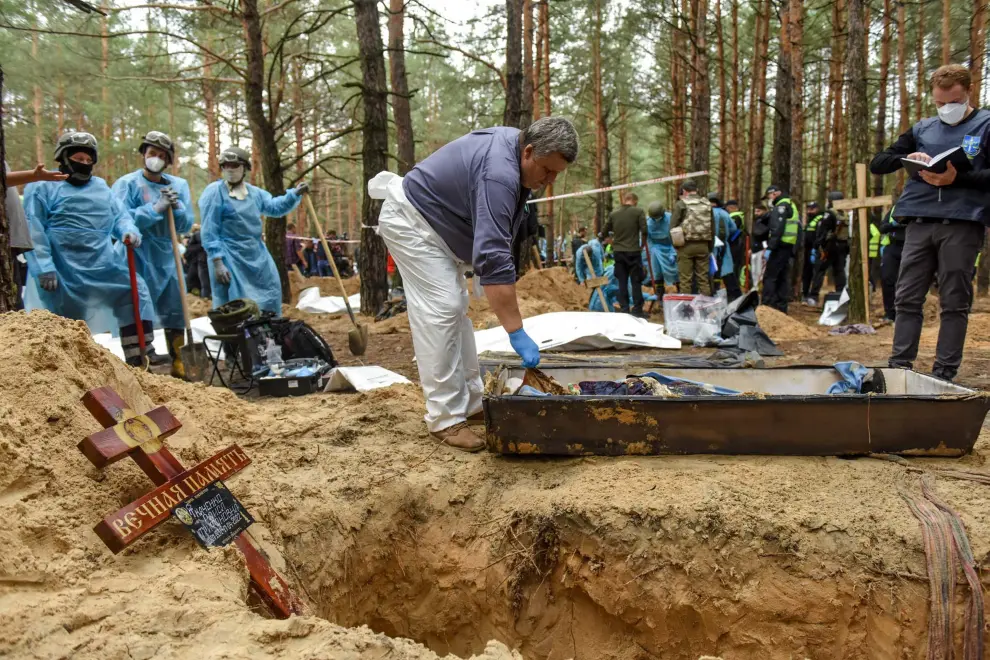 Izyum (Ukraine), 16/09/2022.- Workers exhume bodies from graves in Izyum, Kharkiv region, northeastern Ukraine, 16 September 2022. A mass burial site was found after Ukrainian troops recaptured the town of Izyum. According to the head of the investigative department of the police of the Kharkiv region, the burial site, one of the largest in a recaptured city so far, counts more than 440 separate graves. The Ukrainian army pushed Russian troops from occupied territory in the northeast of the country in a counterattack. Kharkiv and surrounding areas have been the target of heavy shelling since February 2022, when Russian troops entered Ukraine starting a conflict that has provoked destruction and a humanitarian crisis. (Atentado, Rusia, Ucrania) EFE/EPA/OLEG PETRASYUK
 UKRAINE RUSSIA CONFLICT