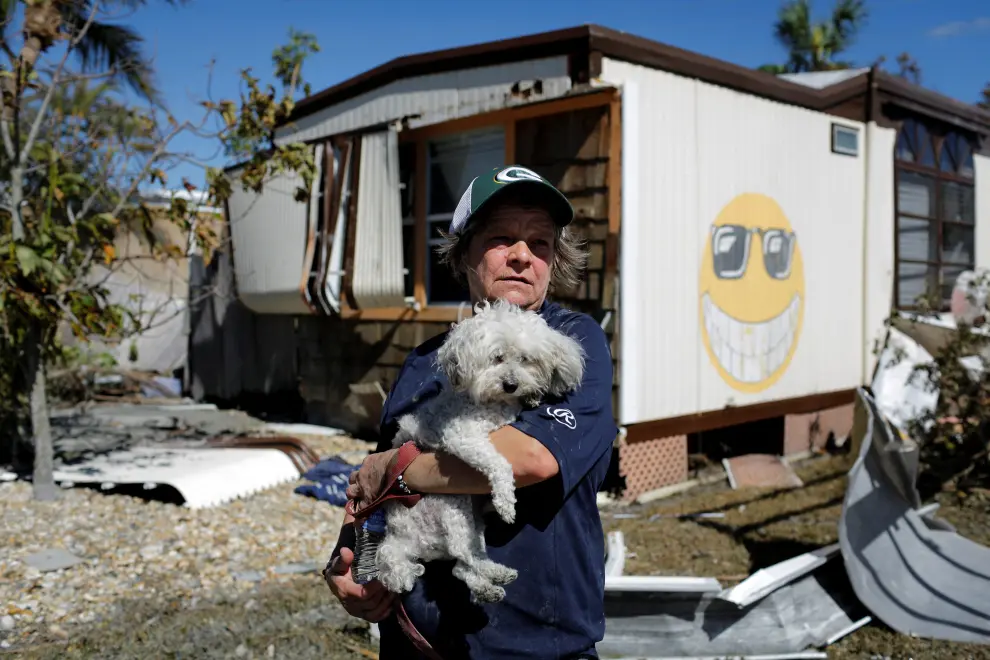 People leave a trailer park carrying their belongings after Hurricane Ian caused widespread destruction in Fort Myers Beach, Florida, U.S., September 30, 2022. REUTERS/Marco Bello STORM-IAN/FLORIDA