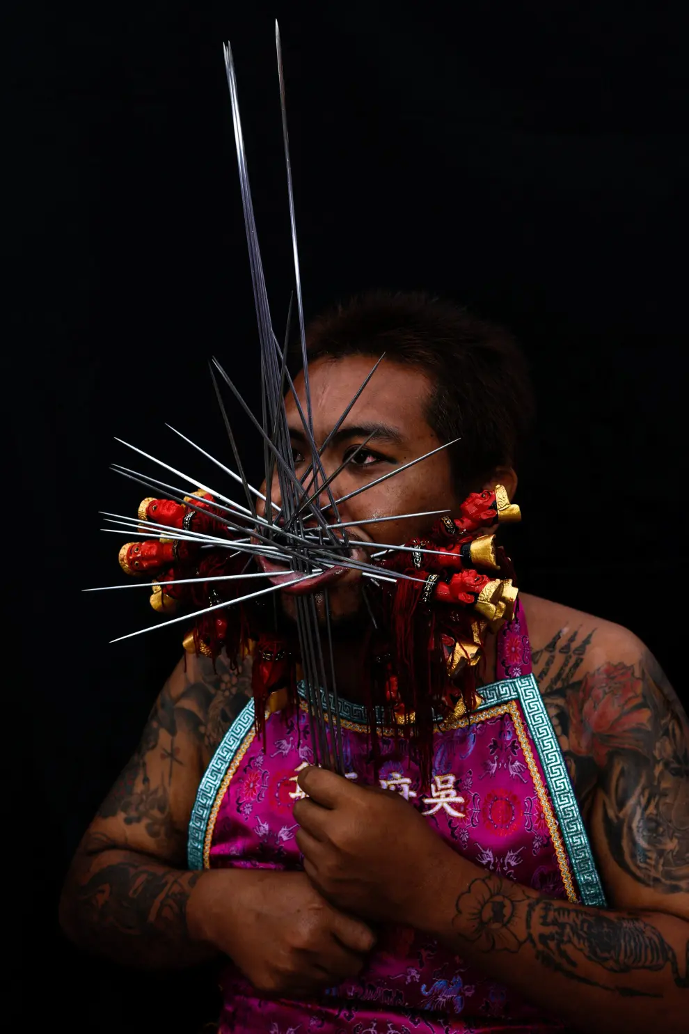 A medium man with his mouth pierced is portrayed while in trance during the Samkong Shrine procession amidst celebrations of the annual vegetarian festival, observed by Taoist devotees from the Thai-Chinese community in the ninth lunar month of the Chinese calendar, in Phuket Town, Thailand September 29, 2022. REUTERS/Jorge Silva THAILAND-RELIGION/PORTRAITS
