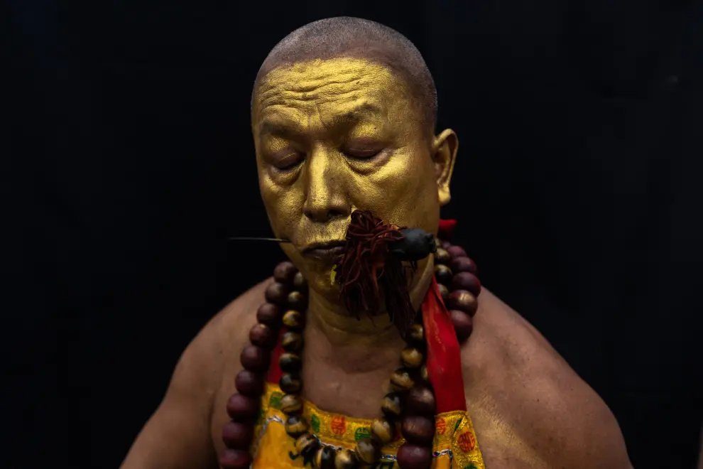 A medium man with his mouth pierced is portrayed while in trance during the Samkong Shrine procession amidst celebrations of the annual vegetarian festival, observed by Taoist devotees from the Thai-Chinese community in the ninth lunar month of the Chinese calendar, in Phuket Town, Thailand September 29, 2022. REUTERS/Jorge Silva THAILAND-RELIGION/PORTRAITS