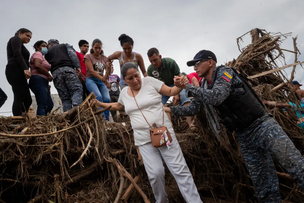 SENSITIVE MATERIAL. THIS IMAGE MAY OFFEND OR DISTURB Rescue members release the body of a person that died during a landslide from among branches and mud, following floods due to heavy rains, in Las Tejerias, Aragua state, Venezuela October 9, 2022. REUTERS/Leonardo Fernandez Viloria     TPX IMAGES OF THE DAY VENEZUELA-WEATHER/