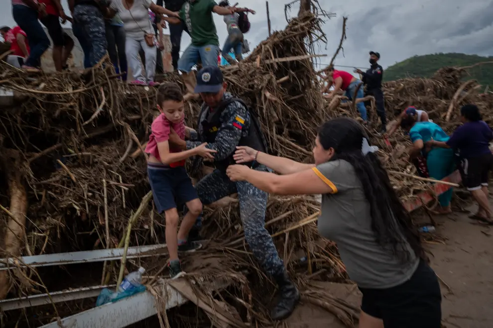 SENSITIVE MATERIAL. THIS IMAGE MAY OFFEND OR DISTURB Rescue members release the body of a person that died during a landslide from among branches and mud, following floods due to heavy rains, in Las Tejerias, Aragua state, Venezuela October 9, 2022. REUTERS/Leonardo Fernandez Viloria     TPX IMAGES OF THE DAY VENEZUELA-WEATHER/