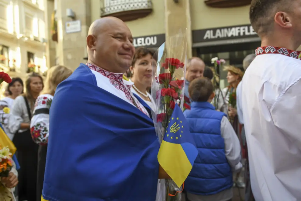 Un hombre envuelto con una bandera de Ucrania.