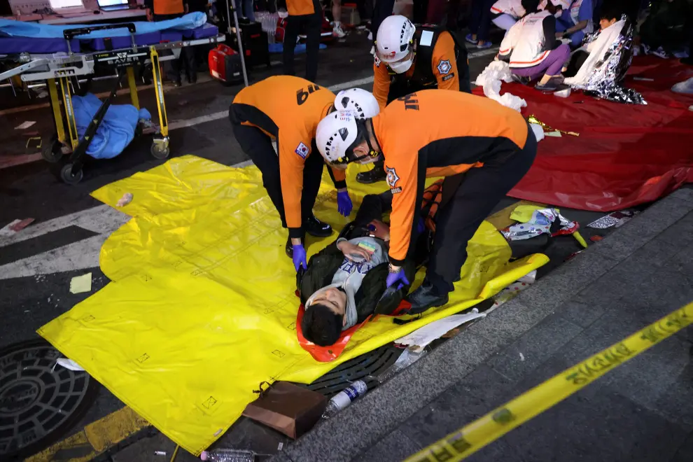 People receive medical help from rescue team members at the scene where dozens of people were injured in a stampede during a Halloween festival in Seoul, South Korea, October 29, 2022. REUTERS/Kim Hong-ji SOUTHKOREA-STAMPEDE/