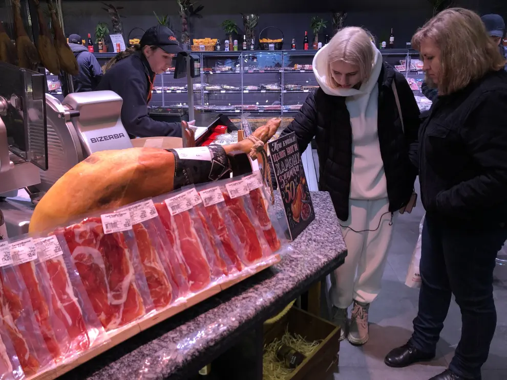 Unas mujeres se interesan por el jamón español del supermercado del centro comercial Nikolsky.