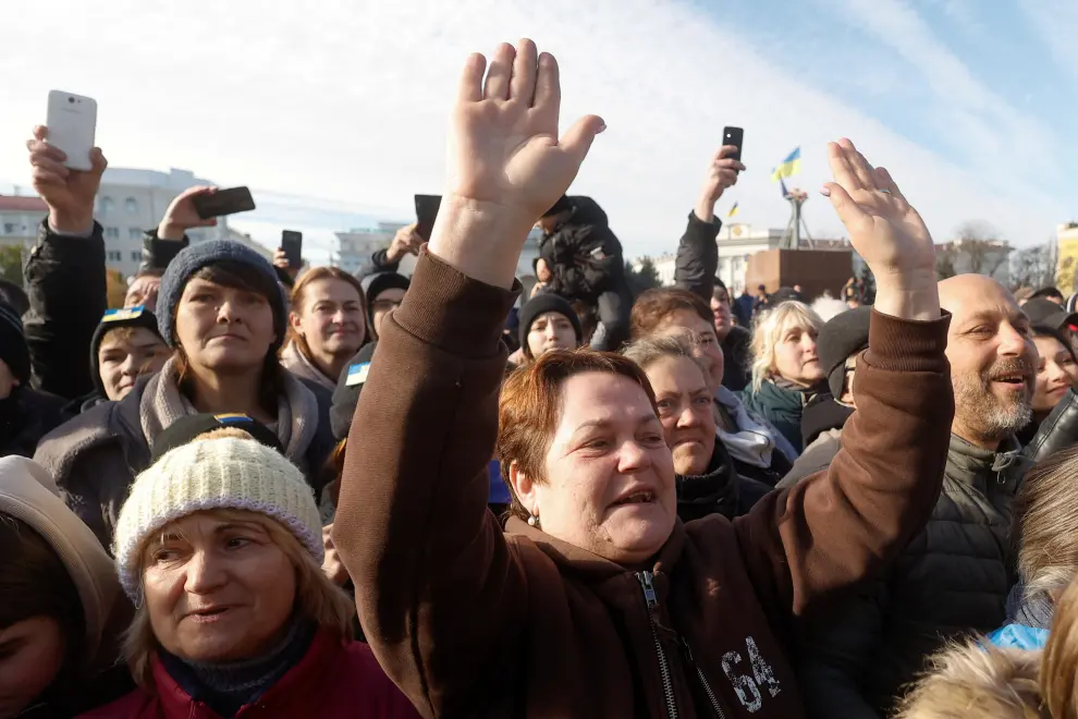 Local residents react during a visit of Ukraine's President Volodymyr in central Kherson