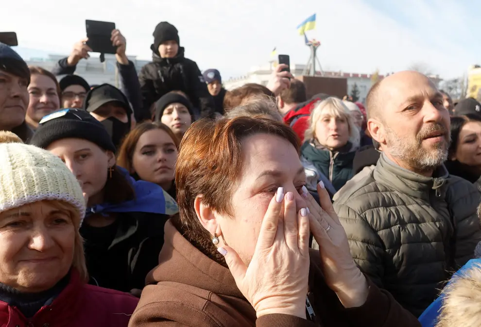 Local residents react during a visit of Ukraine's President Volodymyr in central Kherson