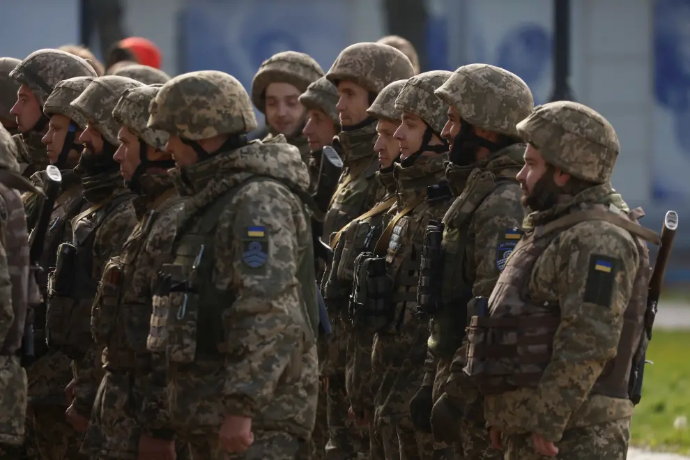 Ukrainian servicemen attend a flag rising in central Kherson
