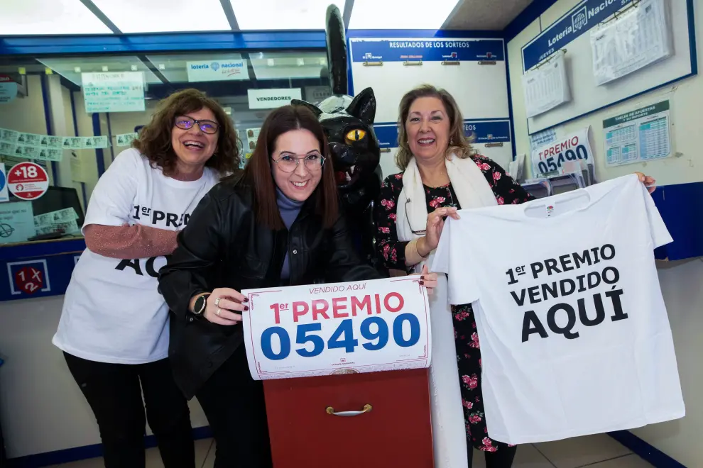 La propietaria de la administración número 11 de Murcia El Gato Negro Teresa Serrano (d) y sus empleados celebran que han vendido décimos del Gordo