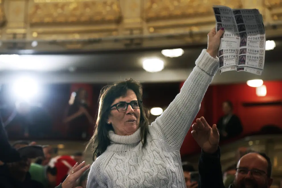 Una mujer del público celebra ser portadora de un quinto premio durante el sorteo de Navidad celebrado en el Teatro Real en Madrid.